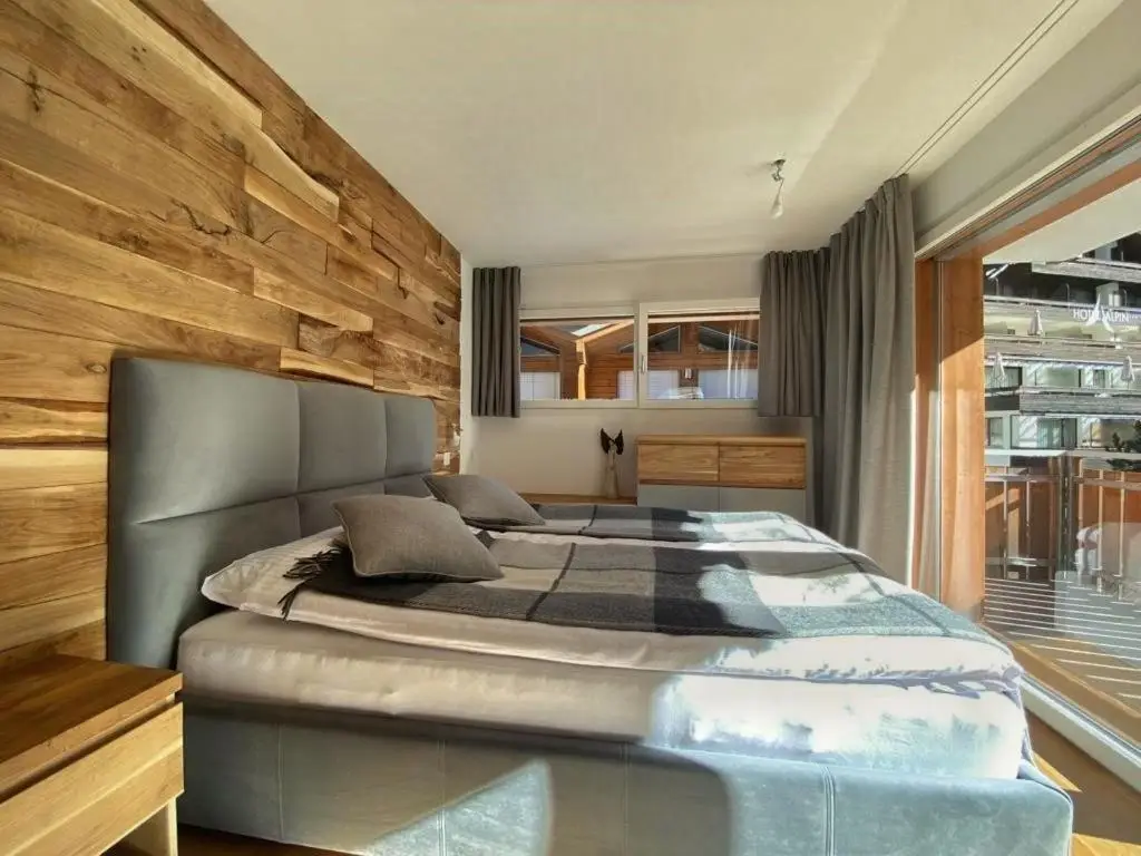 W sypialni poza szafkami nocnymi, zajęliśmy się wykonaniem boazerii drewnianej. Rustykalny styl idealnie wpasował się w nastrój cichej i klimatycznej miejscowości wysoko w Alpach.